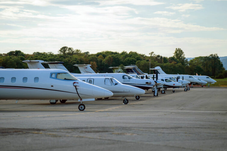 A row of parked bizjets and private aircraft parked at the airport for a Virginia Tech football game